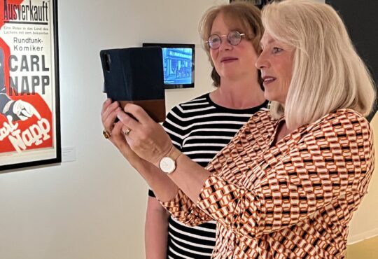Archivleiterin Martina Keiffenheim stellt Tabea Rößner die App für digitalisierten Plakate vor