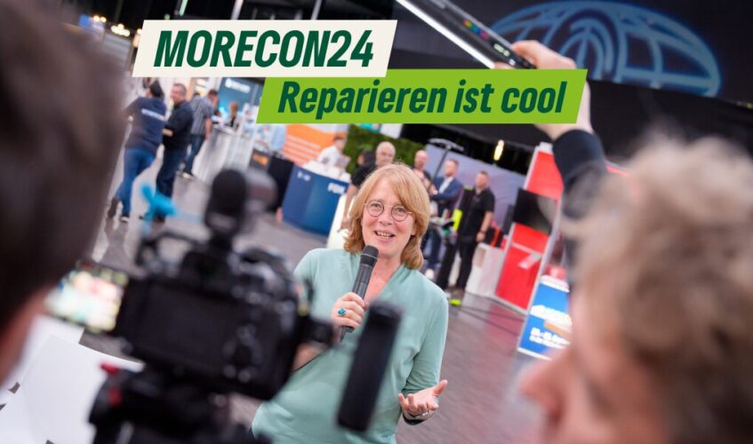 Tabea Rößner steht mit einem Mikrophon auf der MORECON Messe uns spricht in eine Kamera. Copyright Oliver Nimz